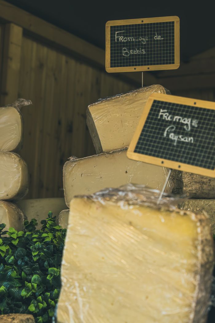 A rustic selection of artisan cheeses at a market stall in Marckolsheim, France.